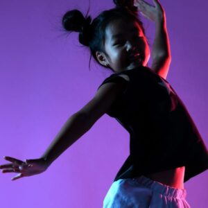 Child jumping in air against a purple light background celebrating receiving a donation